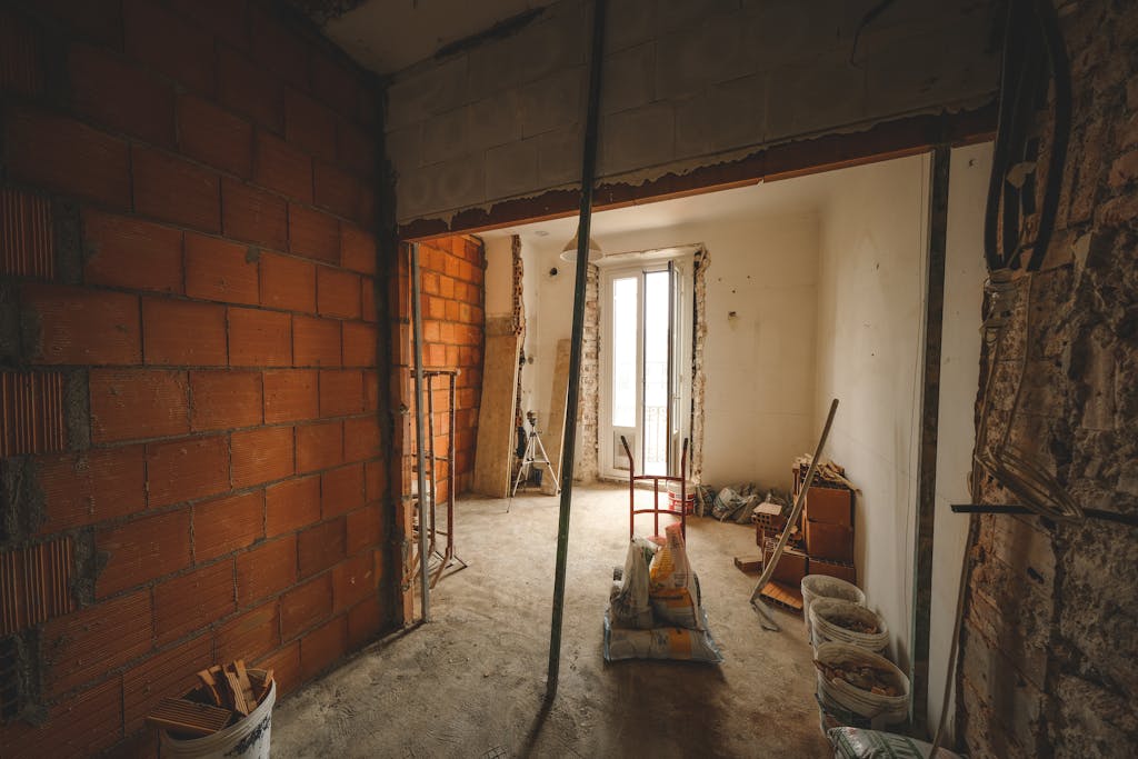 A partially renovated room with exposed brick walls and construction materials on site.