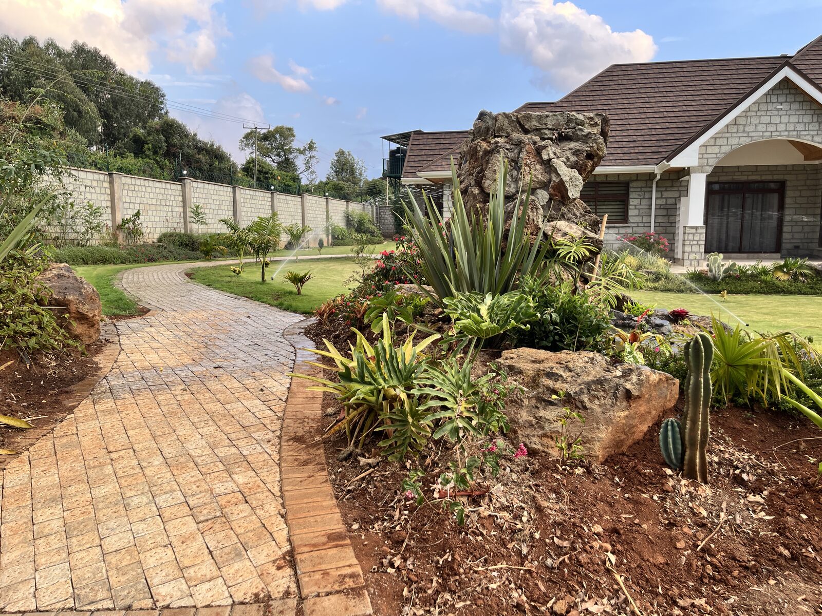 Landscaped garden pathway leading to a stone house