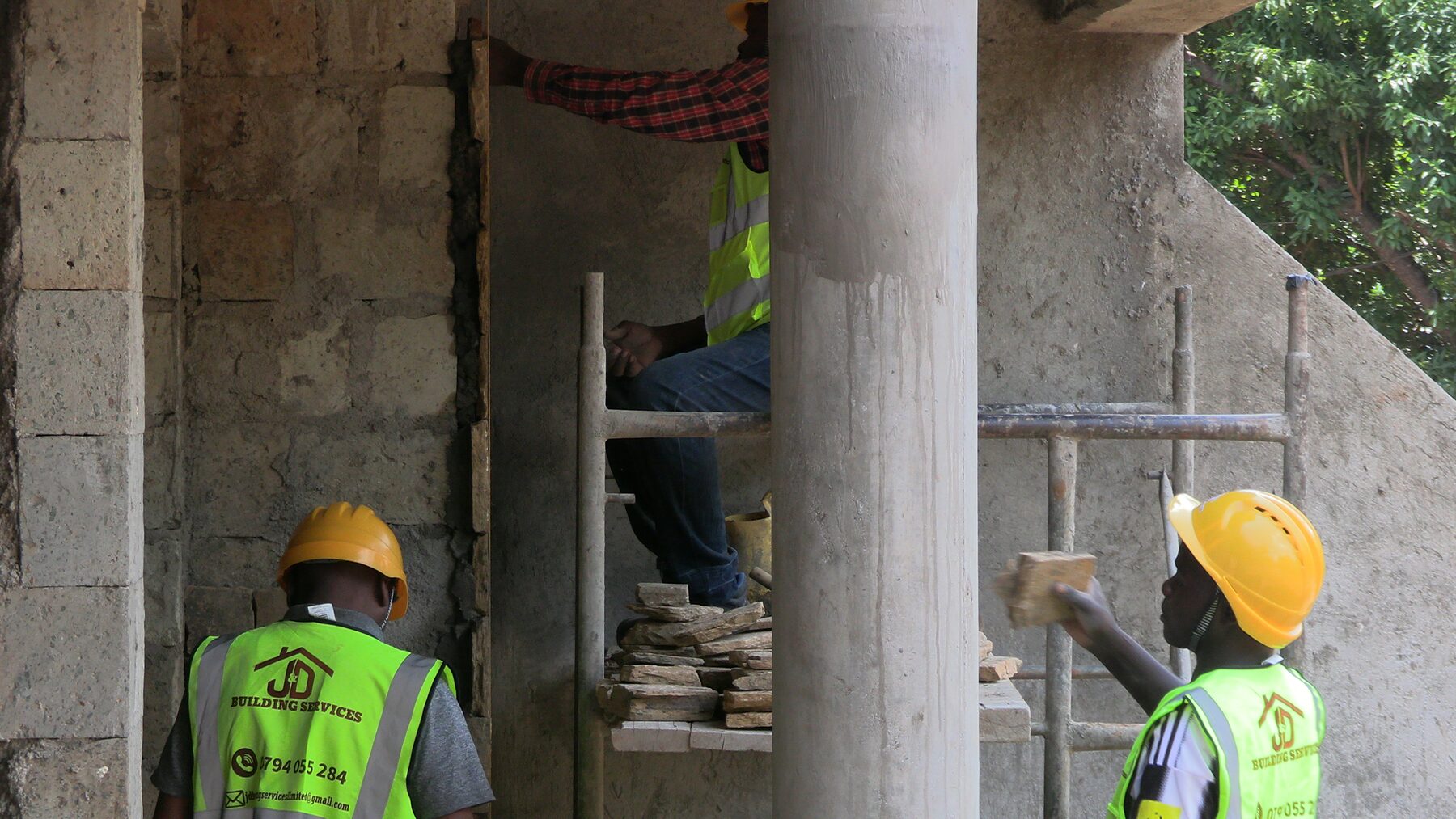 JD Building Services team installing a door frame and stonework finish on site