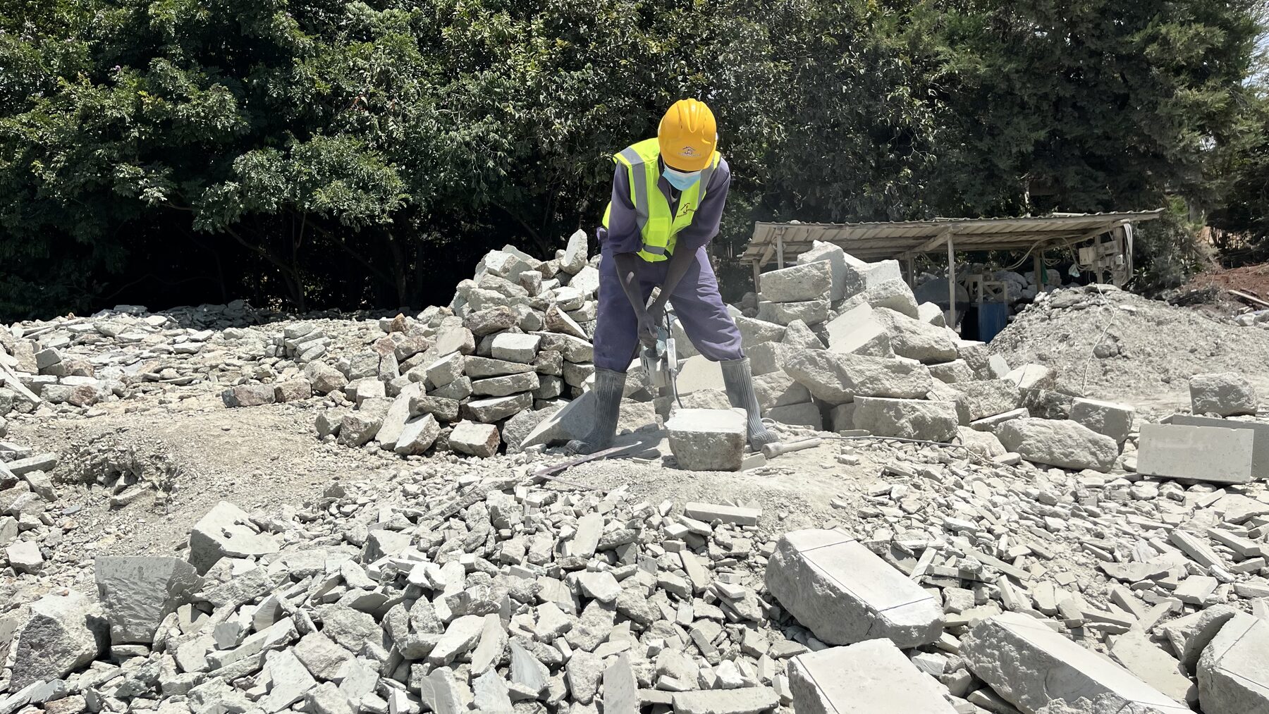 Construction worker breaking stone on a JD Building Services site